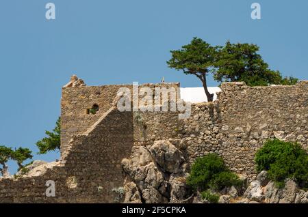 Mur de la forteresse du château médiéval de Monolithos illuminé par le soleil de la clôture (Rhodes, Grèce) Banque D'Images