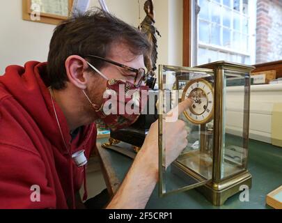 Mikey Martin, étudiante en conservation de l'horloge, ajuste les horloges dans l'atelier de conservation de l'horloge au West Dean College of Arts and conservation à Chichester, dans le West Sussex, avant les horloges qui vont de l'avant pour le début de l'heure d'été britannique le dimanche 28 mars. Date de la photo: Lundi 22 mars 2021. Banque D'Images