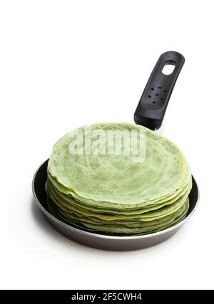 Crêpes fines vertes dans une petite casserole isolée sur blanc Banque D'Images