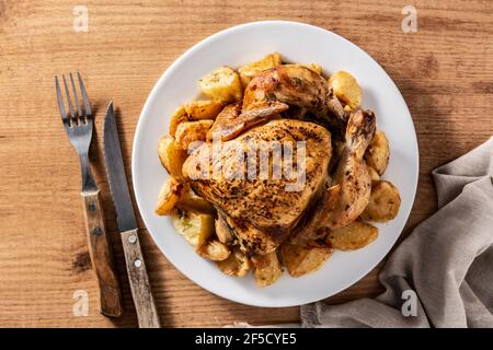 Poulet rôti maison avec pommes de terre sur table en bois Banque D'Images