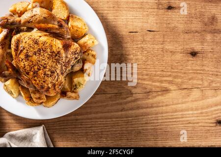 Poulet rôti maison avec pommes de terre sur table en bois Banque D'Images