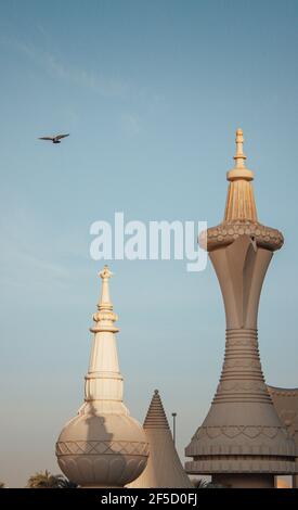 Photo verticale du café Dallah à Abu Dhabi sous le ciel clair avec un oiseau volant Banque D'Images