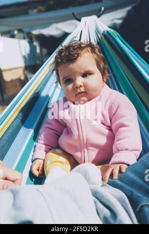 Petit bébé s'amusant sur un hamac dans un temps ensoleillé jour Banque D'Images