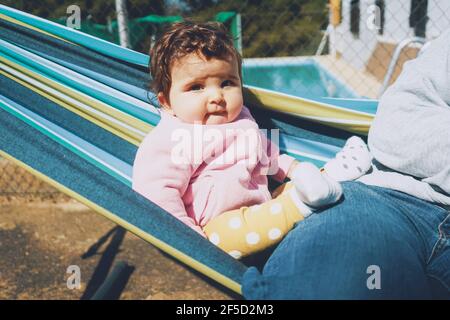 Petit bébé s'amusant sur un hamac dans un temps ensoleillé jour Banque D'Images