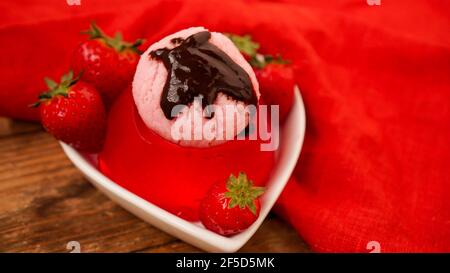 Gelée de fraises dans un bol, décorée de crème glacée maison Banque D'Images
