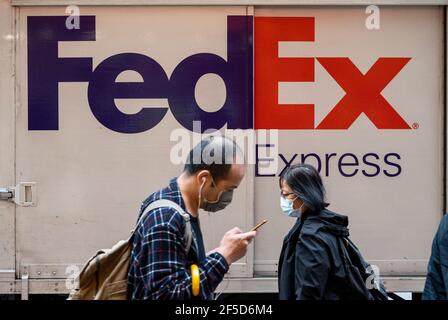 Hong Kong, Chine. 26 mars 2021. Des piétons marchent devant le camion de livraison American FedEx Express vu à Hong Kong. Crédit : SOPA Images Limited/Alamy Live News Banque D'Images