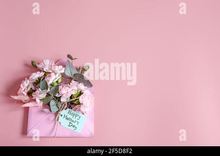 Composition festive avec enveloppe de fleurs fraîches et inscription Happy Mother's Day Flat lay. Banque D'Images