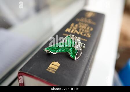 Broche verte sur le livre Seigneur des anneaux. Les feuilles de Lorien étaient des broches données par Galadriel aux membres de la Fellowship de l'anneau à la fin Banque D'Images