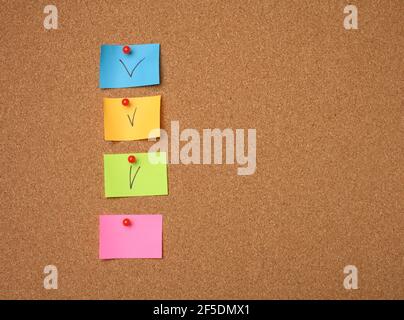 autocollants en papier colorés collés au panneau en liège marron, espace de copie Banque D'Images