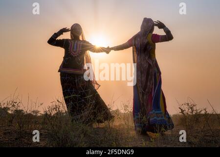 Deux silhouettes de femmes gitanes danser une danse traditionnelle au coucher du soleil, Pushkar Camel Fair, Pushkar, Rajasthan, India Banque D'Images