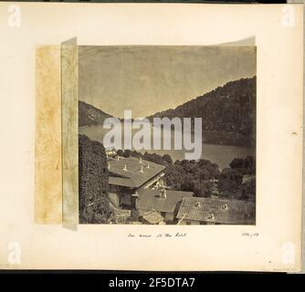 Nos chambres à l'Hôtel. Vue sur le lac Nainital et le paysage boisé et montagneux environnant. Les toits d'un complexe résidentiel sont visibles au premier plan, ainsi qu'une partie de la terrasse et les côtés des bâtiments. Plusieurs autres bâtiments peuvent être vus sur les collines au loin. (Recto, mount) en bas à droite, manuscrit à encre noire: 'Octr 1/68'' en bas à gauche, manuscrit à crayon: 'A42.57 (Bou)' en bas au centre, manuscrit à encre noire: 'Nos chambres à l'hôtel' Banque D'Images