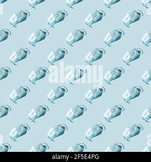 Motif avec masques de protection sur fond bleu. Protection contre les virus et la grippe. Banque D'Images