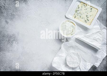 Variété de fromages sur table de cuisine, brie, Camembert, Gorgonzola et fromage bleu crémeux. Arrière-plan blanc. Vue de dessus. Copier l'espace Banque D'Images
