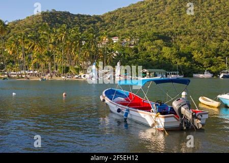 Marigot Bay, Castries, Sainte-Lucie. Bateau-taxi coloré amarré au bord de l'eau, LABAS Beach en arrière-plan. Banque D'Images