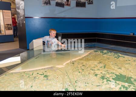 Un jeune garçon utilisant une carte interactive à la Pegasus Musée du pont Banque D'Images