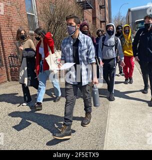 Les élèves du secondaire marchant sur le trottoir après la réouverture de l’école à Brooklyn, NY au printemps 2021, toujours confrontés à la pandémie de COVID-19. Banque D'Images