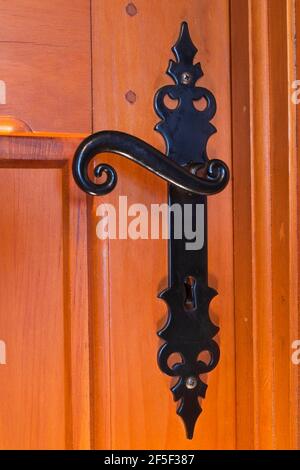 Gros plan de poignée de porte en métal antique noir sur la chambre en bois porte à l'intérieur d'une ancienne maison de style cottage de 1807 Banque D'Images