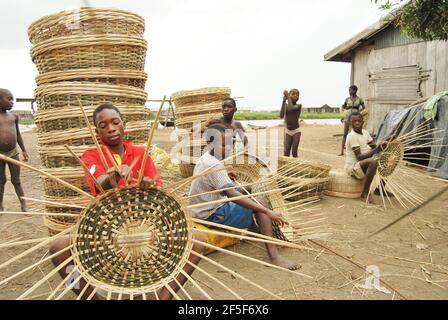 Les enfants tissage des paniers dans la jupe de l'État d'Ondo, au Nigeria. Banque D'Images