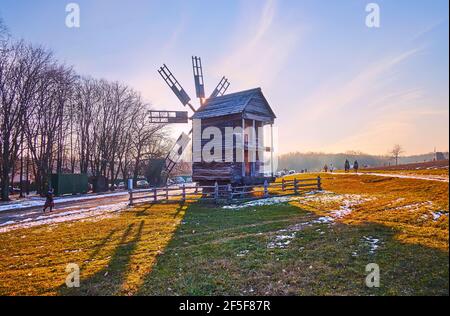 Le soleil du soir est vu à travers les voiles de l'ancien moulin à vent en bois, Pyrohiv Skansen, Kiev, Ukraine Banque D'Images