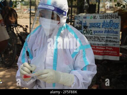 New Delhi, Inde. 26 mars 2021. Un travailleur de la santé portant un équipement de protection individuelle (EPI) a vu marquer un échantillon d'écouvillon d'un passager pour un test de RT-PCR Covid-19 sur le côté de la route à Shalimar Bagh.en Inde, 59,118 nouveaux cas confirmés de covid-19 ont été enregistrés dans les dernières 24 heures et le 69e jour de la vaccination 55 Million de doses de vaccin Covid-19 administrées, et jusqu'à présent 23, 58,731 doses de vaccin ont été administrées au cours des 24 dernières heures. (Photo par Naveen Sharma/SOPA Images/Sipa USA) crédit: SIPA USA/Alay Live News Banque D'Images