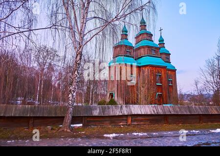 La vue de la grande église St Paraskeva derrière la clôture en bois et avec le bouleau en premier plan, Pyrohiv Skansen, Kiev, Ukraine Banque D'Images