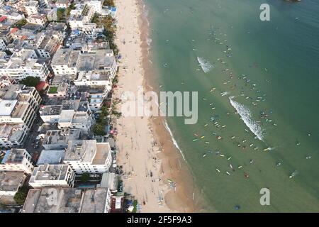 (210326) -- SANYA, le 26 mars 2021 (Xinhua) -- photo aérienne prise le 25 février 2021 montre les amateurs de surf pratiquant le surf dans le village de Tenghai de Sanya, dans la province de Hainan, au sud de la Chine. Le village de Tenghai, autrefois un petit village de pêcheurs, est devenu un célèbre camp de surf depuis le boom du surf en Chine, après avoir officiellement admis le surf dans le programme des Jeux Olympiques de Tokyo en 2020. Situé à Sanya, dans la province de Hainan au sud de la Chine, le village a également été reconnu pour sa grande combinaison de sports nautiques et d'industrie touristique.Yang Xingfu, un villageois local, est l'un des premiers surfeurs de Tenghai. Oui Banque D'Images