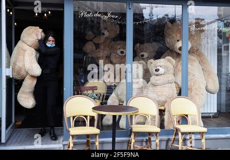 Paris, France. 26 mars 2021. Le propriétaire du café bouquet Wagram, qui fournit des services à emporter, porte un ours en peluche géant à Paris, France, le 26 mars 2021. Le ministre français de la Santé, Olivier Veran, a annoncé jeudi des « mesures de freinage forcé » dans trois autres régions à haut risque de la COVID-19 -- Rhône, Aube et Nièvre -- dans le but de contenir une troisième vague de la pandémie. Credit: Gao Jing/Xinhua/Alamy Live News Banque D'Images