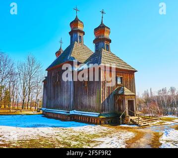 Le début du printemps à Pyrohiv Skansen - la vue de l'église médiévale St Michael au milieu de la cour enneigée, Kiev, Ukraine Banque D'Images