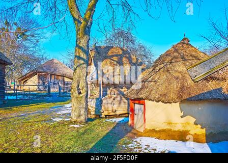 Le parc de jeux en bois et les bâtiments en argile de granges et de stockage sur le terrain de ferme historique typique, Pyrohiv Skansen, Kiev, Ukraine Banque D'Images