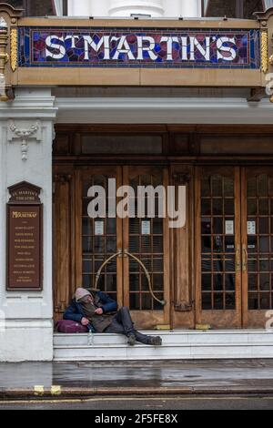 Un homme sans domicile s'assoit sur les marches du St Martin Theatre, dans le West End de Londres, avant que le coronavirus LockDown n'ait organisé la production du Mousetrap. Banque D'Images