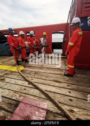 le marin a effectué un exercice d'incendie mensuel sur le pont, pour rafraîchir sa formation et tester toutes les pompes d'incendie et les tuyaux d'incendie d'urgence Banque D'Images