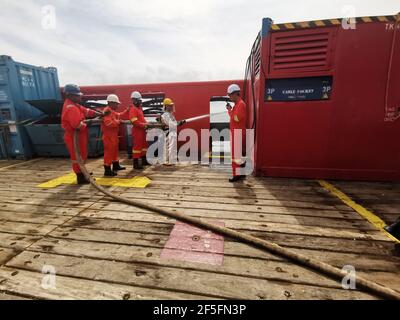 le marin a effectué un exercice d'incendie mensuel sur le pont, pour rafraîchir sa formation et tester toutes les pompes d'incendie et les tuyaux d'incendie d'urgence Banque D'Images