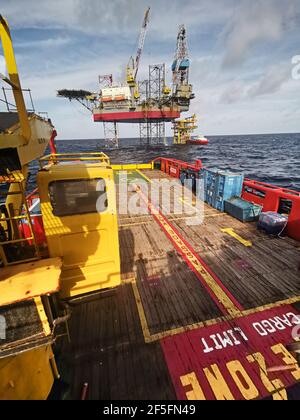 le navire de ravitaillement en mer s'approche lentement de la plate-forme pétrolière pendant une zone de 500 mètres jusqu'à la plate-forme pétrolière pour l'approvisionnement en fret Banque D'Images