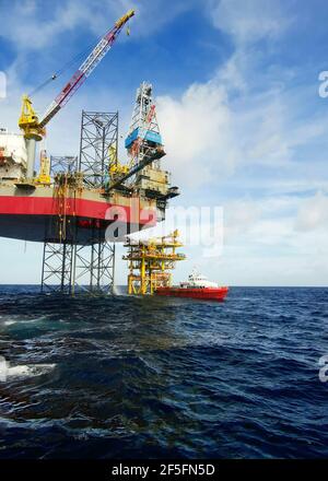 le navire de ravitaillement en mer s'approche lentement de la plate-forme pétrolière pendant une zone de 500 mètres jusqu'à la plate-forme pétrolière pour l'approvisionnement en fret Banque D'Images