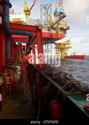 le navire de ravitaillement en mer s'approche lentement de la plate-forme pétrolière pendant une zone de 500 mètres jusqu'à la plate-forme pétrolière pour l'approvisionnement en fret Banque D'Images