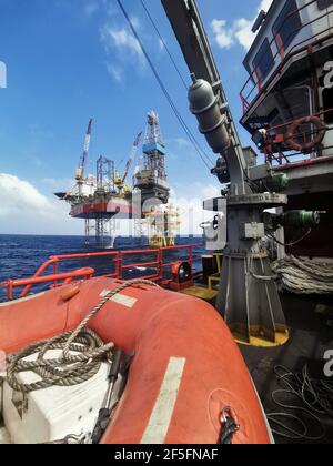 le navire de ravitaillement en mer s'approche lentement de la plate-forme pétrolière pendant une zone de 500 mètres jusqu'à la plate-forme pétrolière pour l'approvisionnement en fret Banque D'Images