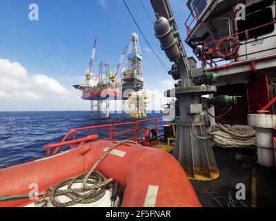 le navire de ravitaillement en mer s'approche lentement de la plate-forme pétrolière pendant une zone de 500 mètres jusqu'à la plate-forme pétrolière pour l'approvisionnement en fret Banque D'Images