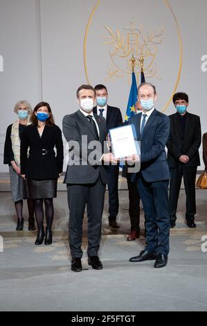 Paris, France. 26 mars 2021. Le président français Emmanuel Macron détient conjointement un document le long de l'historien Vincent Duclert, qui dirige la commission rwandaise et son équipe (derrière) à la salle des Fete à l'Elysée Palace à Paris, en France, le 26 mars 2021. Photo par Eric Tschaen/Pool/ABACAPRESS.COM crédit: Abaca Press/Alay Live News Banque D'Images