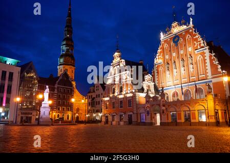 Maison des Têtes Noires, la place de l'Hôtel de Ville, statue de Roland, Rue et église Saint Pierre lit up at night, Riga, Lettonie Banque D'Images