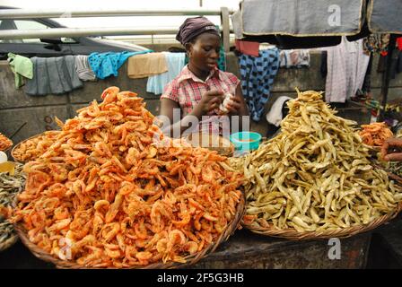 Une femme qui vend des écrevisses dans une rue de Lagos, au Nigeria. Banque D'Images