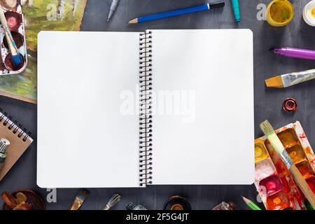 Carnet de croquis au pinceau et aux tubes avec outils de peintre à la texture d'arrière-plan de table abstraite. Concept de peintre artistique et pinceau Banque D'Images