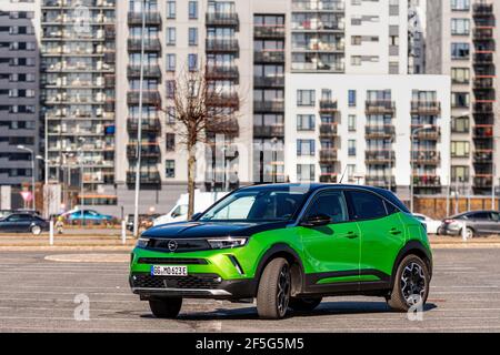 Riga, Lettonie - 26 mars 2021: Véhicule électrique vert Opel Mokka-e dans le parking sur le fond d'une zone résidentielle urbaine Banque D'Images