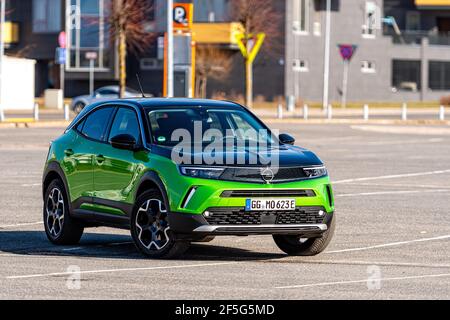 Riga, Lettonie - 26 mars 2021: Véhicule électrique vert Opel Mokka-e dans le parking sur le fond d'une zone résidentielle urbaine Banque D'Images