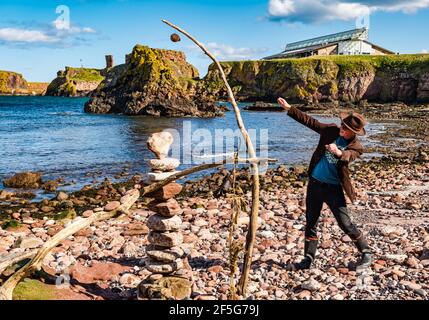 James Craig page, gerbeur en pierre, pierres empilées pour créer une sculpture sur roche sur la plage Eye Cave, Dunbar, East Lothian, Écosse, Royaume-Uni Banque D'Images