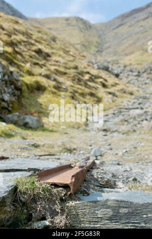 Les restes de travaux miniers: Voies ferrées en métal rouillé dans une ancienne carrière d'ardoise dans les montagnes.Gros plan sur l'équipement ; une piste entre les rochers Banque D'Images