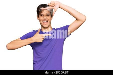 Jeune hispanique portant des vêtements décontractés souriant faisant cadre avec les mains et les doigts avec le visage heureux. Créativité et concept de photographie. Banque D'Images