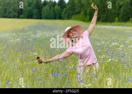 Belle femme d'âge moyen profitant des activités de plein air en été, en marchant dans la prairie. Bonne, joyeuse, femme de 55 ans à la tête d'une saine Banque D'Images