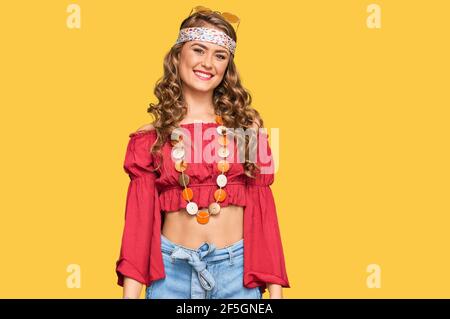 Jeune fille blonde portant le style bohème et hippie a l'air positif et se tenir debout et sourire avec un sourire confiant dents Banque D'Images