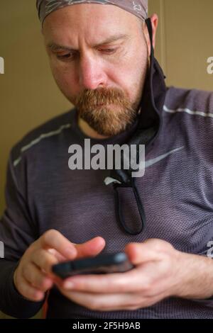 Sardaigne, Ohio, États-Unis. 25 mars 2021. Dave WHITSON, un marcheur d'un océan à l'autre, regarde les informations météorologiques sur un orage imminent sur son téléphone en Sardaigne, Ohio, le 25 mars 2021. Whitson, un professeur d'école secondaire de Portland, OU a été inspiré de marcher d'un océan à l'autre après avoir fait de la marche de Cincinnati à Denver en 2019.en février 2020, Whitson a commencé à marcher à Cape Henloopen, DE et a suspendu sa marche deux fois en 2020 en raison de restrictions et de préoccupations concernant COVID-19.après avoir atteint Cincinnati le 27 mars, Whitson retournera à son lycée pour terminer l'année scolaire et pour passer en revue les options pour le salut Banque D'Images