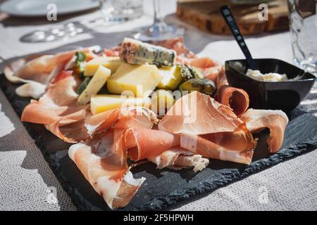 Une photo d'une assiette de speck et de salami italien typique avec du fromage et des cornichons, Cortina d'Ampezzo, Italie Banque D'Images